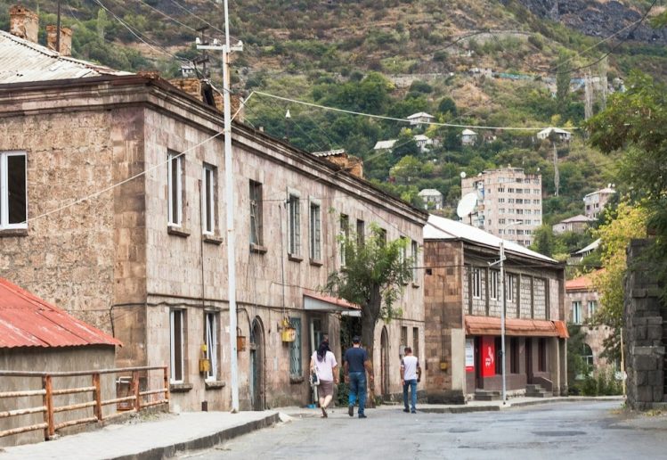 a group of people walking down a street next to buildings