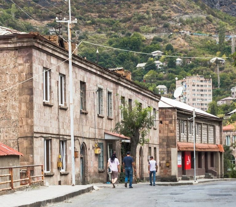a group of people walking down a street next to buildings